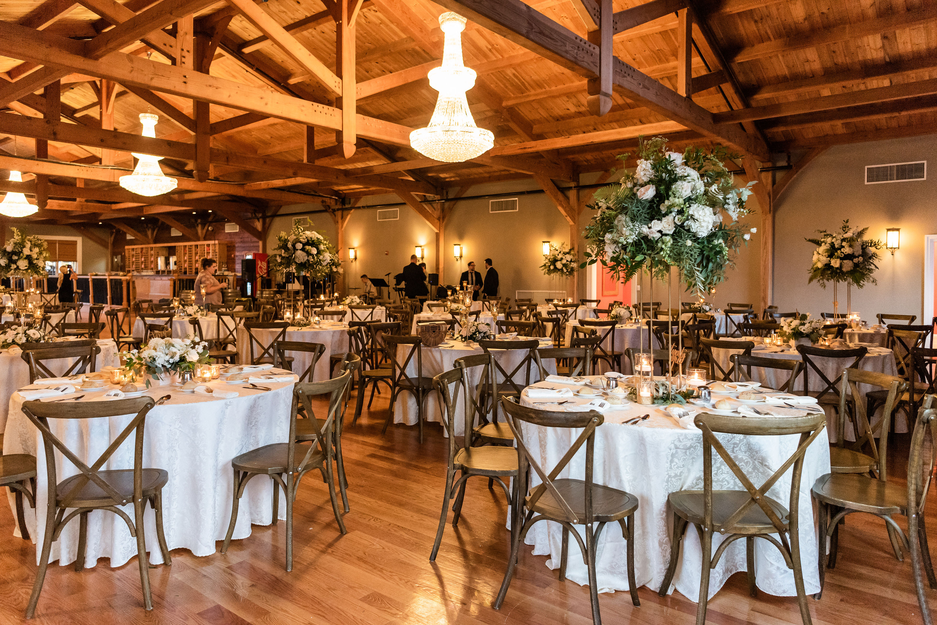 Post and beam Ballroom set with ivory linens and cross back chairs at Willow Creek Winery